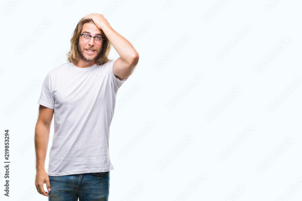 Fototapeta premium Young handsome man with long hair wearing glasses over isolated background surprised with hand on head for mistake, remember error. Forgot, bad memory concept.