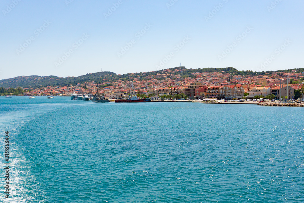 View of Argostoli city in Kefalonia, Greece from the ferry boat sailing to Lixouri. Water trail foaming behind the ferry.