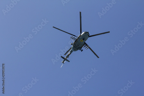 Military helicopter maneuvers in the blue sky