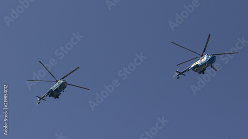 Fototapeta Naklejka Na Ścianę i Meble -  Several military helicopters fly side by side against the blue sky