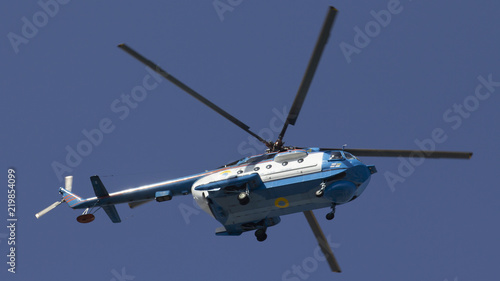 Military helicopter maneuvers in the blue sky