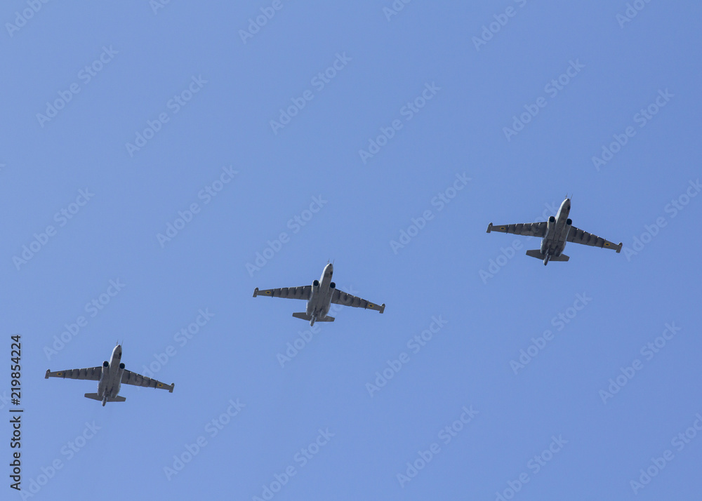 Several military fighters are flying in a formation against the blue sky Several military fighters are flying in a formation against the blue sky