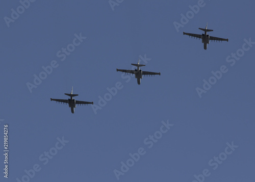 Several military fighters are flying in a formation against the blue sky