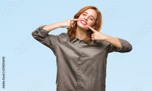 Young beautiful woman over isolated background smiling confident showing and pointing with fingers teeth and mouth. Health concept.