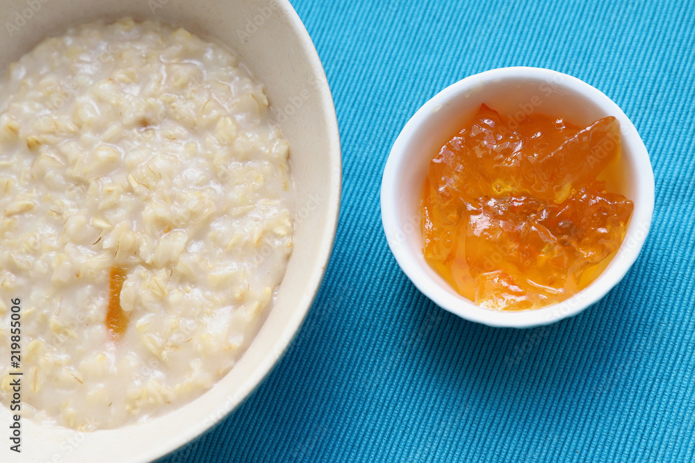 Porridge and orange jam or marmalade for morning breakfast on bright table Porridge and orange jam or marmalade for morning breakfast on bright table