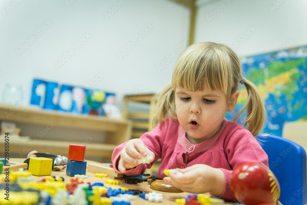 Little caucasian girl playing with wooden puzzle Little caucasian girl playing with wooden puzzle