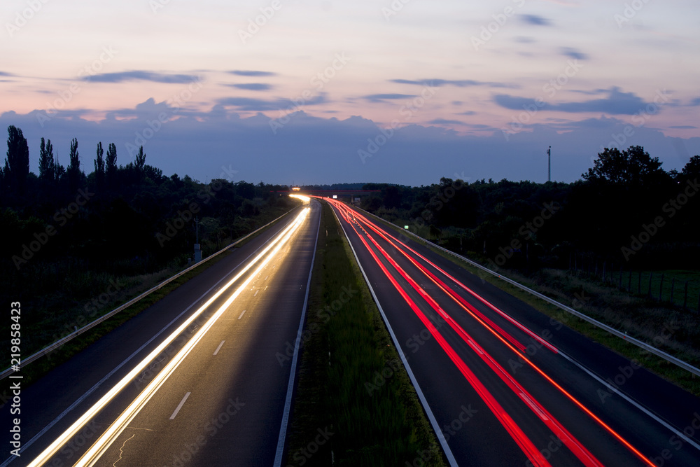 Hungarian highway at night showing vehicles lights, low shutter speed, top view, sky background.