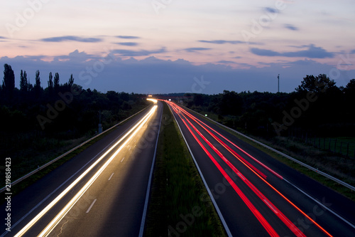 Hungarian highway at night showing vehicles lights, low shutter speed, top view, sky background.