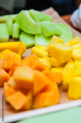 Sliced Chunks of Pineapple, Cantaloupe, Papaya, Mango and Honeydew Melon on a Plate