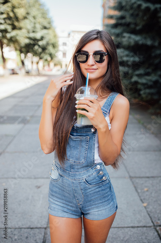 Beautiful young girl with mojito on the summer street photo