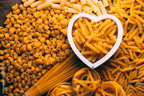 Table full of different types of pasta with a heart shape in the middle, pasta lovers