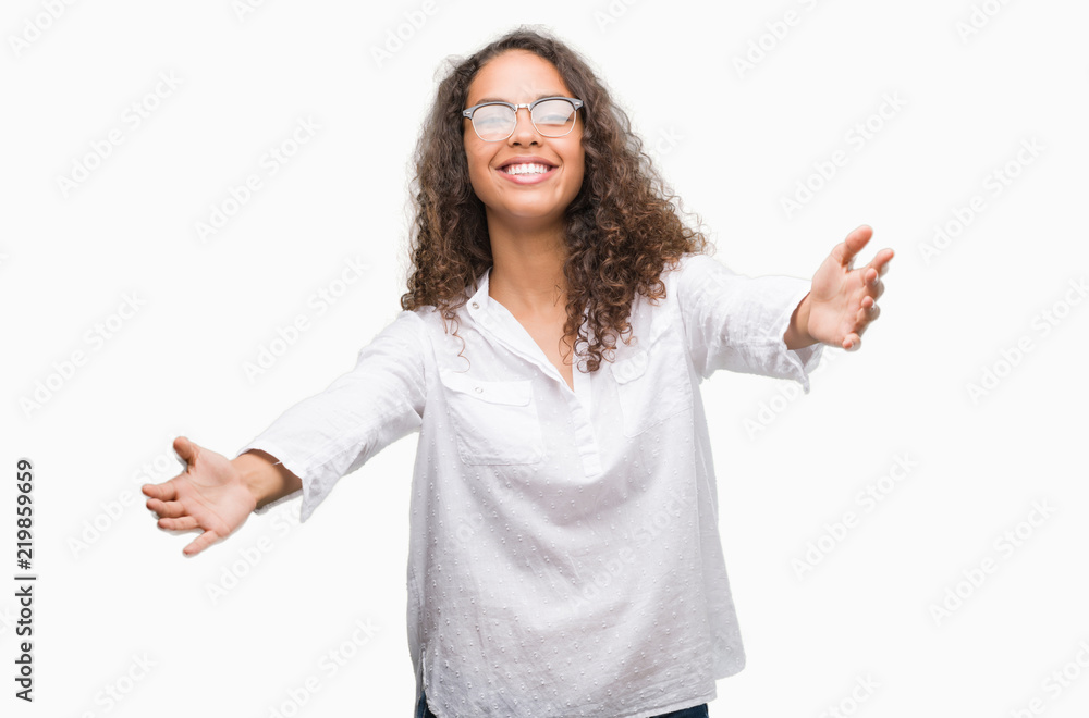 Beautiful young hispanic woman looking at the camera smiling with open arms for hug. Cheerful expression embracing happiness. Beautiful young hispanic woman looking at the camera smiling with open arms for hug. Cheerful expression embracing happiness.