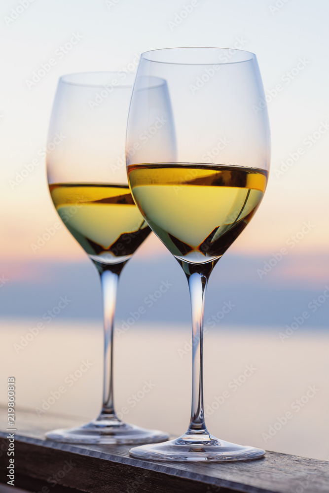 Two glasses of wine against the backdrop of the setting sun, closeup