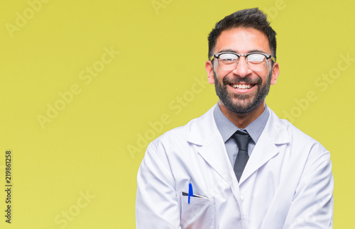 Adult hispanic scientist or doctor man wearing white coat over isolated background happy face smiling with crossed arms looking at the camera. Positive person. © Krakenimages.com