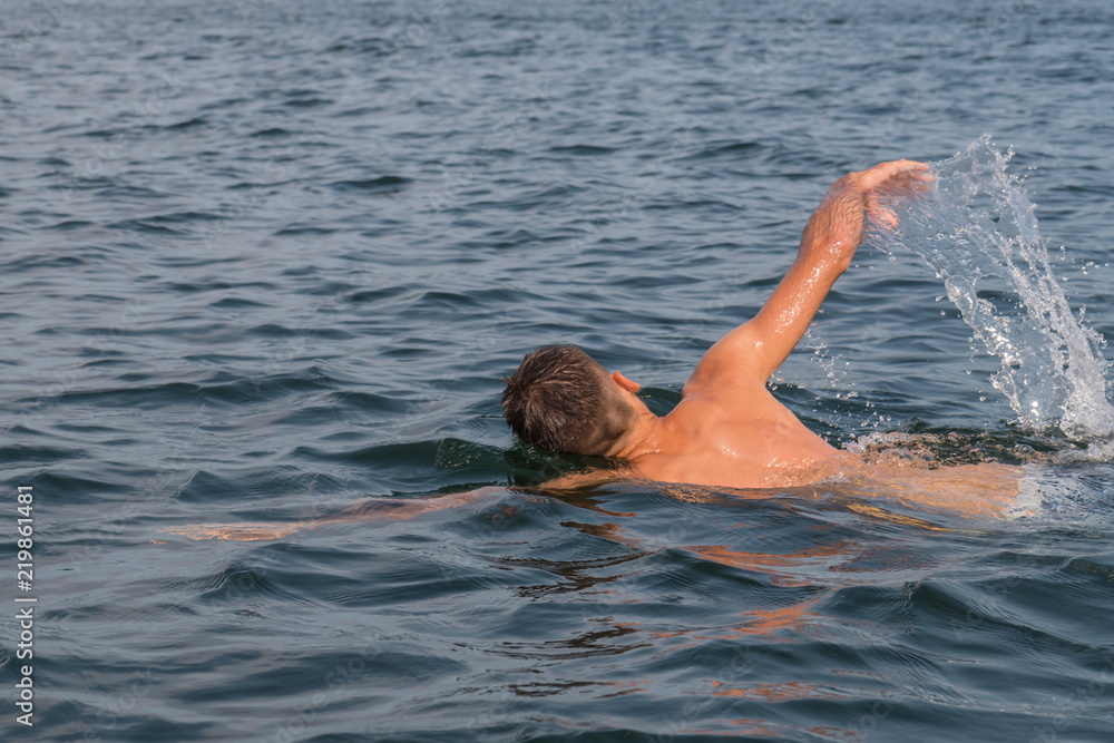 Young man swimming in the lake