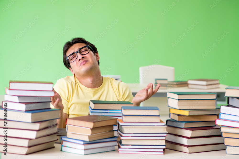 Student with too many books to read before exam Student with too many books to read before exam