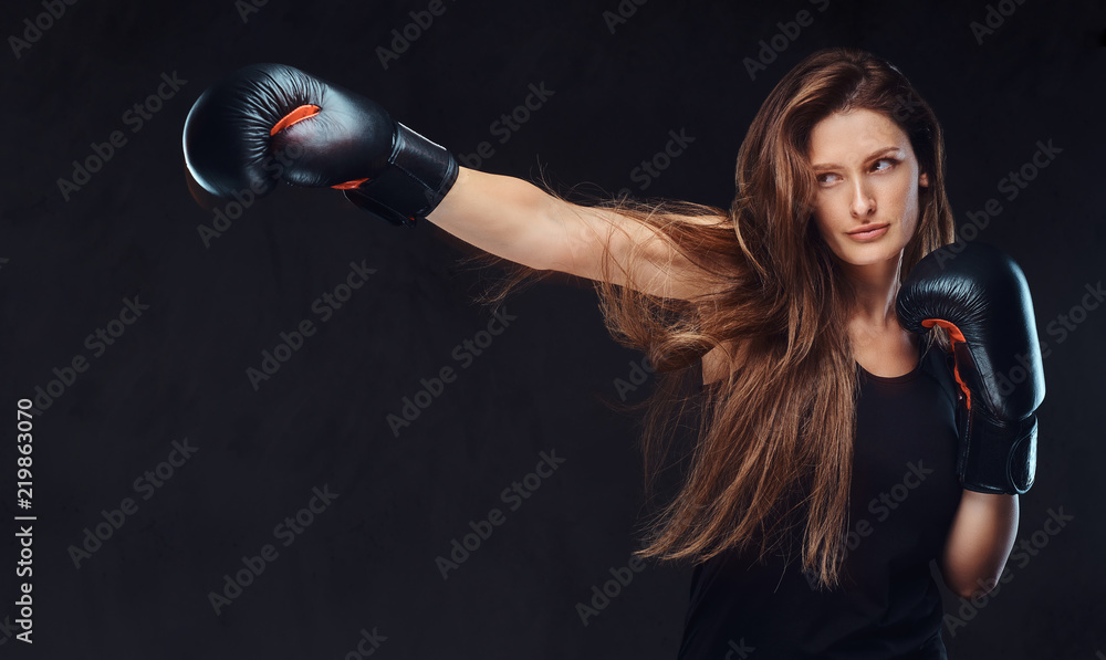 Beautiful brunette female boxer during boxing exercises, focused on a process with serious concentrated facial. Beautiful brunette female boxer during boxing exercises, focused on a process with serious concentrated facial.
