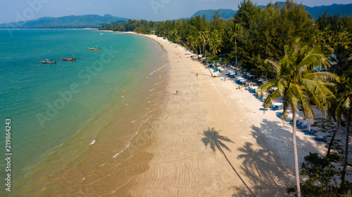 Aerial view of late afternoon shadows being cast onto a beautiful tropical sandy beach in Thailand (Coconut Beach, Khao Lak) photo