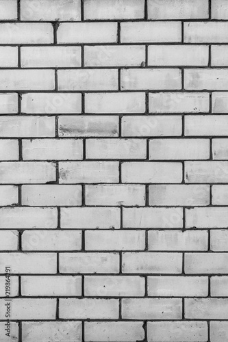 texture of a wall from a natural white brick with small cracks and chips, close-up abstract background