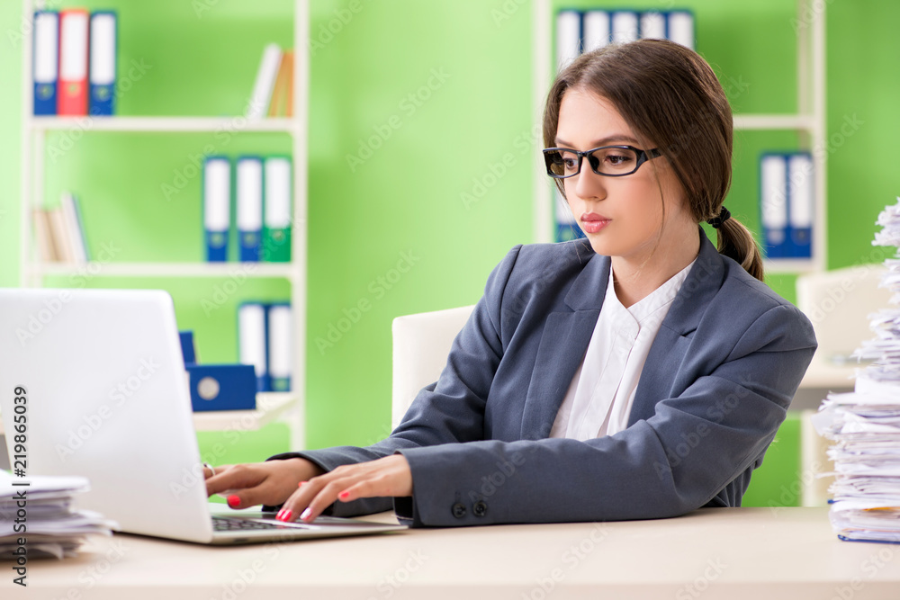 Young female employee very busy with ongoing paperwork Young female employee very busy with ongoing paperwork