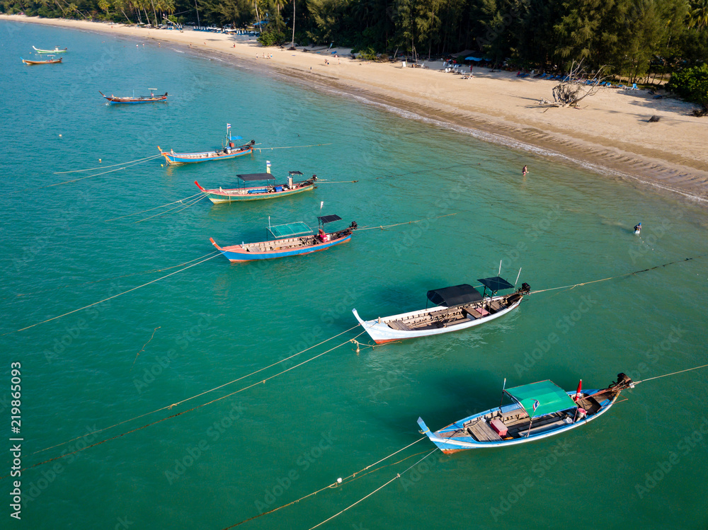 Aerial drone view of colorful traditional Longtail fishing boats at anchor in a shallow bay