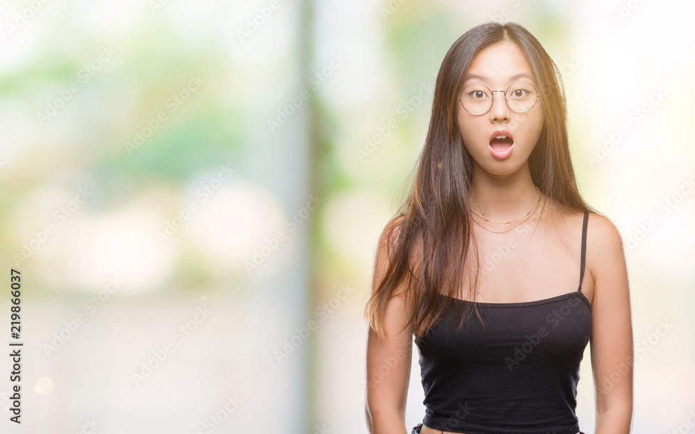 Young asian woman wearing glasses over isolated background afraid and shocked with surprise expression, fear and excited face.
