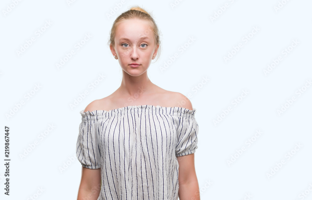 Blonde teenager woman wearing a bun with a confident expression on smart face thinking serious Blonde teenager woman wearing a bun with a confident expression on smart face thinking serious