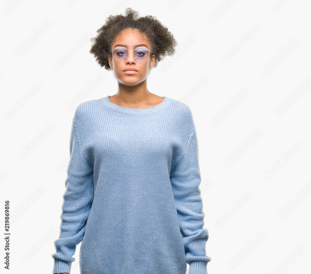 Young afro american woman wearing glasses over isolated background with serious expression on face. Simple and natural looking at the camera. Young afro american woman wearing glasses over isolated background with serious expression on face. Simple and natural looking at the camera.