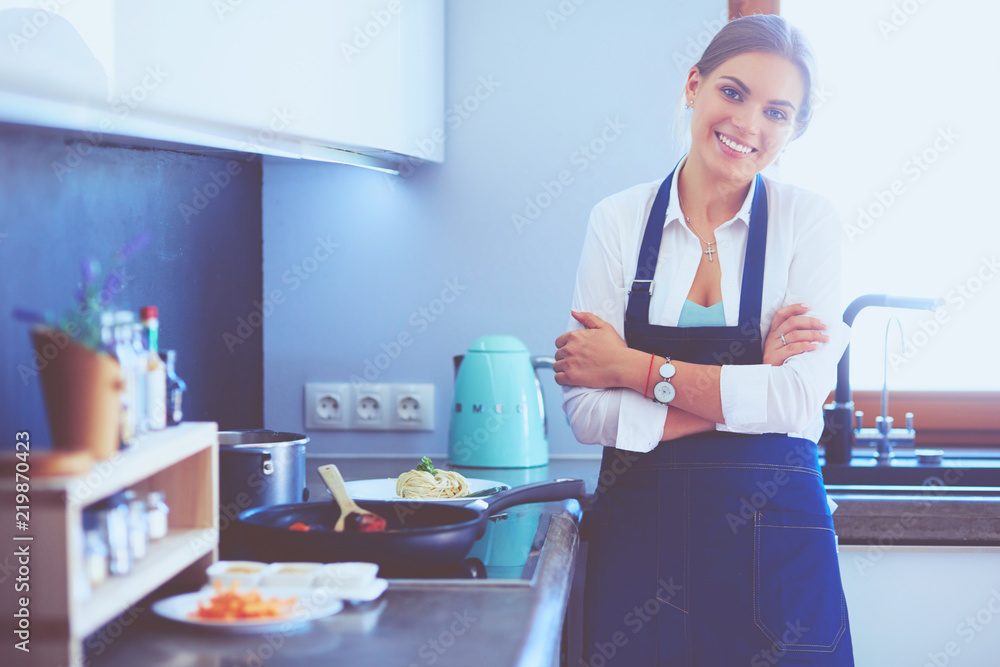 Young woman standing near desk in the kitchen Young woman standing near desk in the kitchen