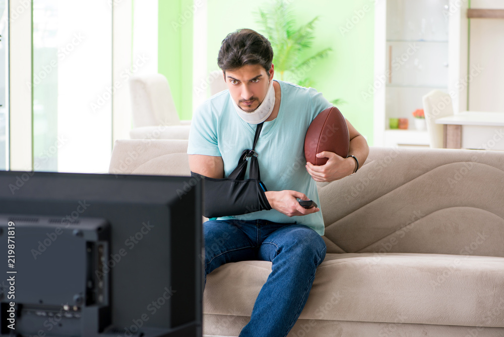 Man with neck and arm injury watching american football on tv Man with neck and arm injury watching american football on tv