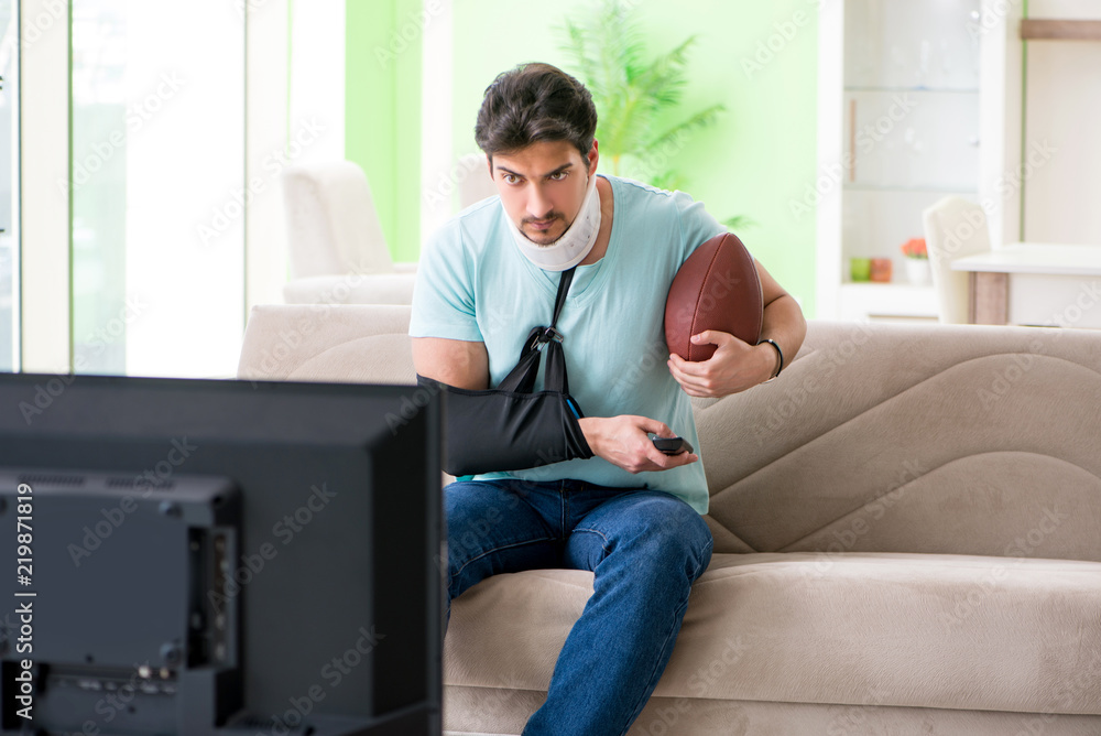 Man with neck and arm injury watching american football on tv