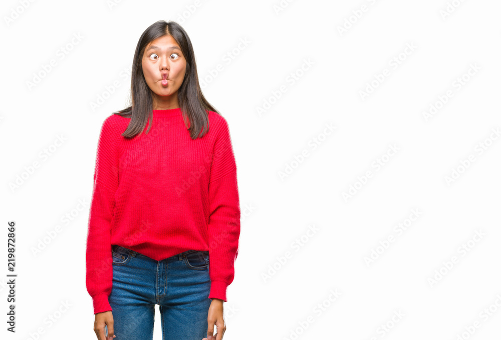 Young asian woman wearing winter sweater over isolated background making fish face with lips, crazy and comical gesture. Funny expression. Young asian woman wearing winter sweater over isolated background making fish face with lips, crazy and comical gesture. Funny expression.