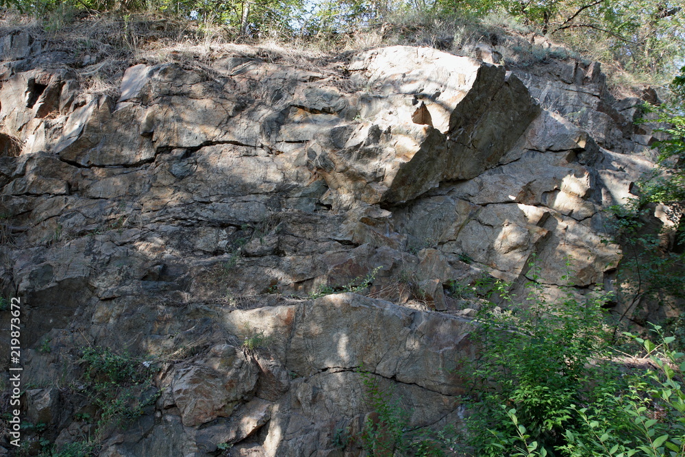 Granite rocks in the sun. Texture of granite stone. Background of natural material. Rocky rocks of ancient times Granite rocks in the sun. Texture of granite stone. Background of natural material. Rocky rocks of ancient times