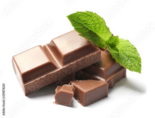 Pieces of milk chocolate with mint on white background