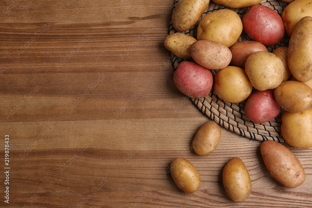 Flat lay composition with fresh organic potatoes on wooden background