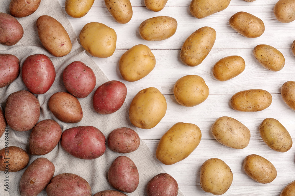 Flat lay composition with fresh organic potatoes on wooden background Flat lay composition with fresh organic potatoes on wooden background