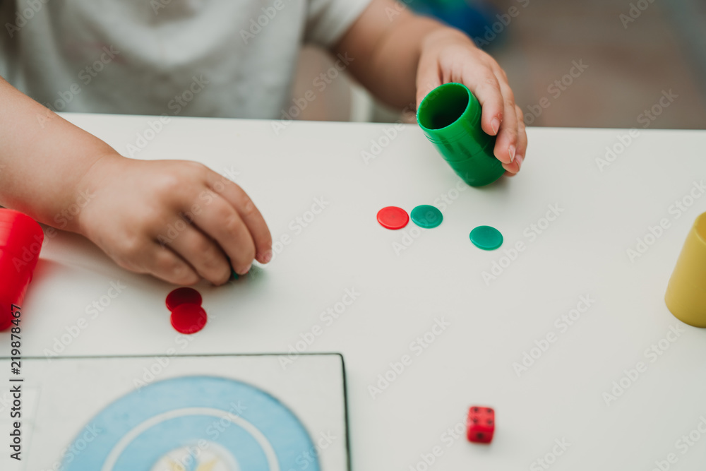 Manos de niña jugando al parchis Manos de niña jugando al parchis