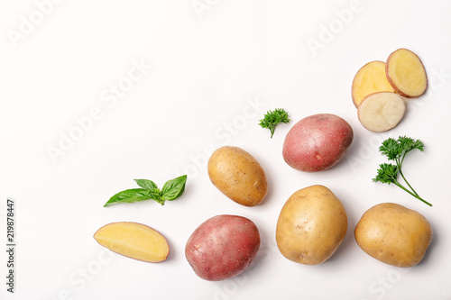 Flat lay composition with fresh organic potatoes and space for text on white background