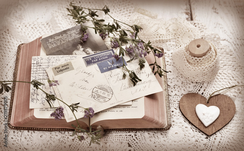 vintage postcards and a book on wooden table in sepia