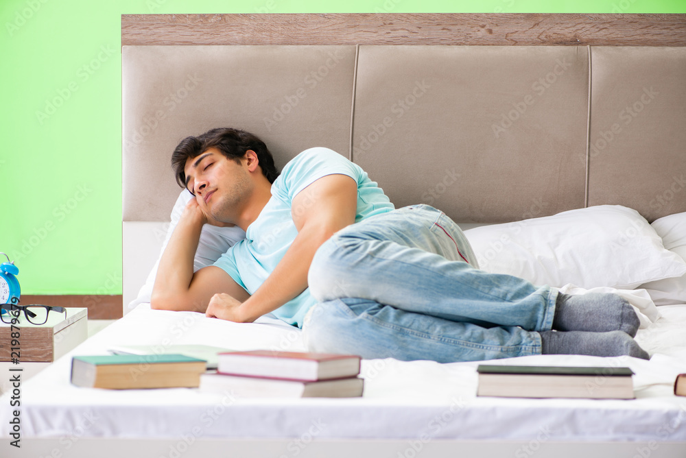 Student preparing for exams at home in bedroom lying on the bed Student preparing for exams at home in bedroom lying on the bed