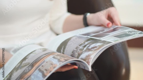 Close up. Beautiful girl reading women's magazine gloss
