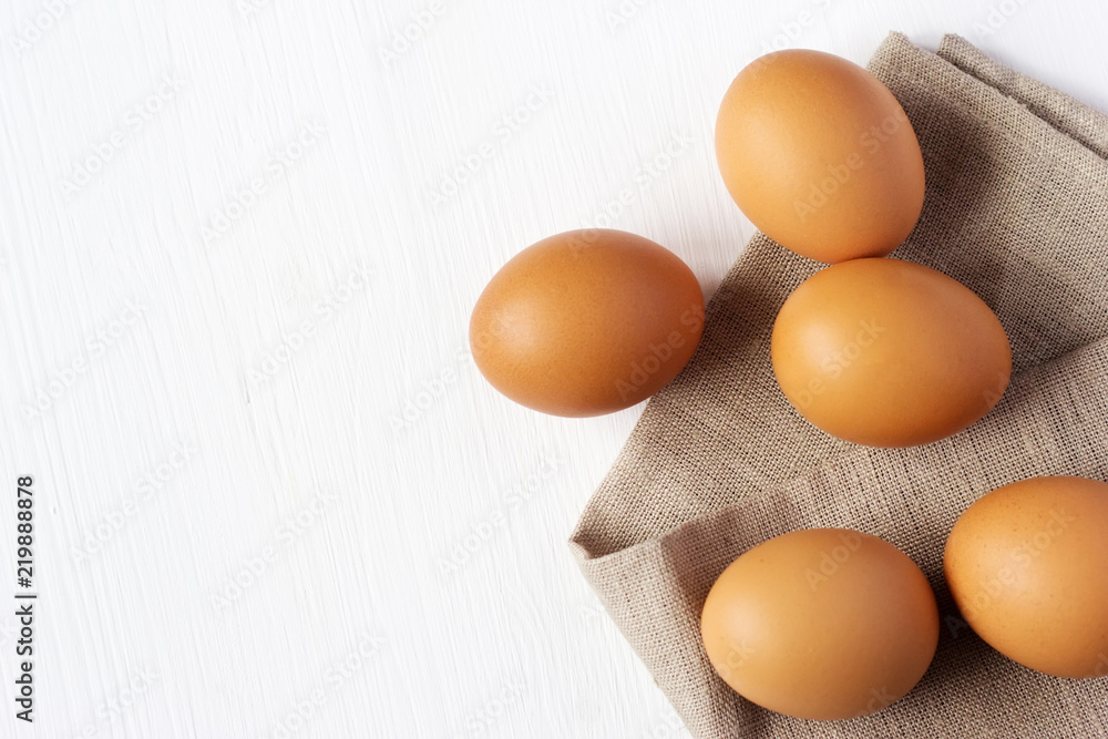Brown chicken eggs on burlap on a white background Brown chicken eggs on burlap on a white background