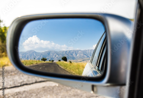 Road and mountains in the mirror auto landscape