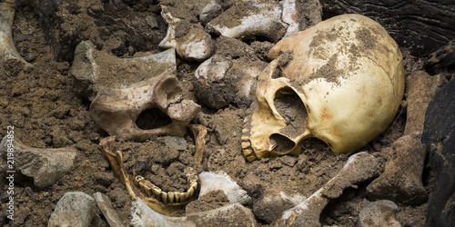 Model skull of human and bones form pit with dark light.Copy space.Concept halloween day.