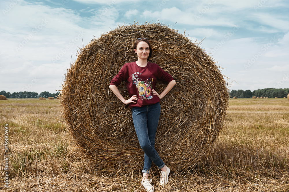 young girl having fun in the field, mowed hay wrapped in a haystack young girl having fun in the field, mowed hay wrapped in a haystack