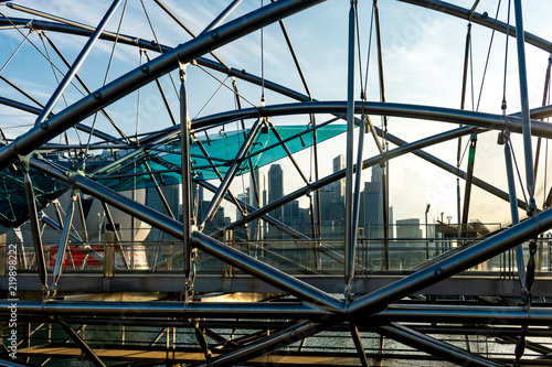 The Singapore skyline through a bridge design near sunset with the skyscrapers int he background