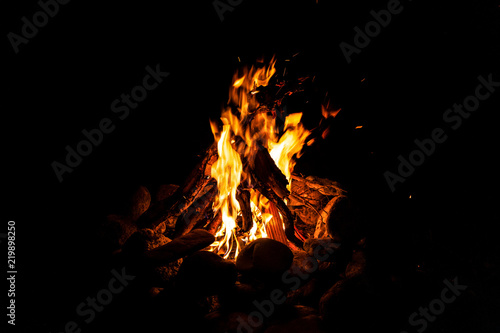 Close-up of a fire with an orange and red flame burning in the dark