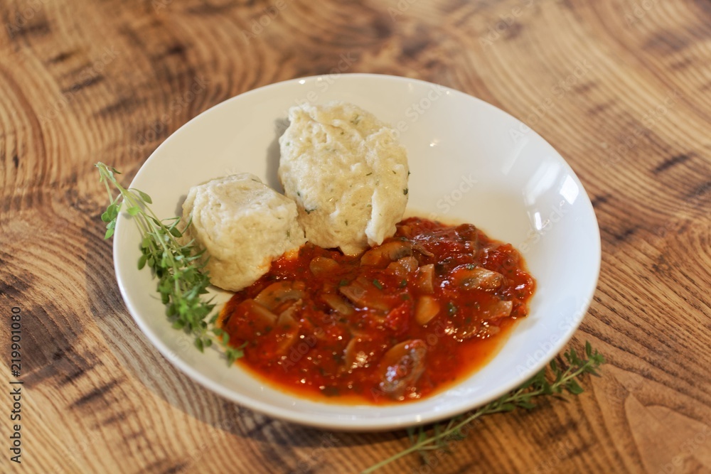 South Tyrolian cheese dumplings with tomato sauce on a white plate South Tyrolian cheese dumplings with tomato sauce on a white plate
