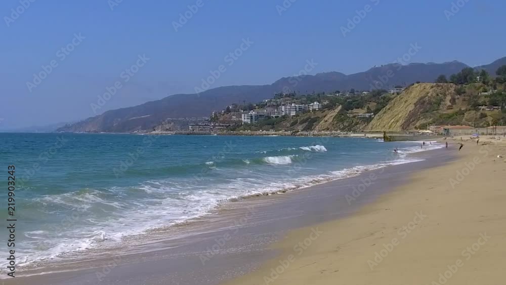 Slow motion waves crashing on a Santa Monica beach landscape on a sunny summer morning Slow motion waves crashing on a Santa Monica beach landscape on a sunny summer morning
