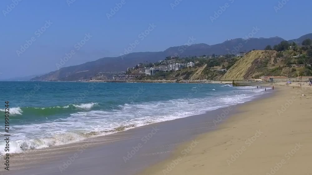 Slow motion waves crashing on a Santa Monica beach landscape on a sunny summer morning Slow motion waves crashing on a Santa Monica beach landscape on a sunny summer morning